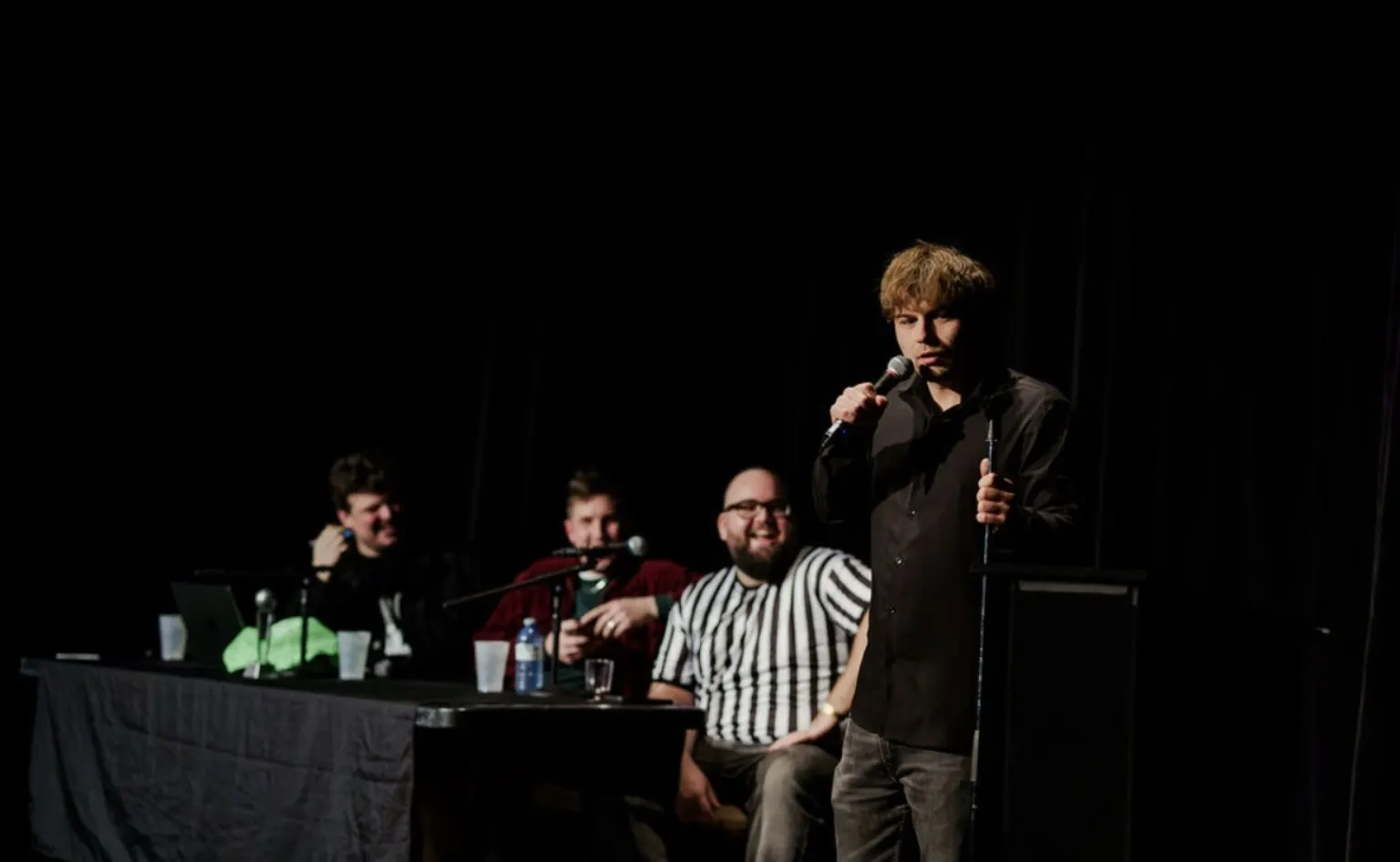 Comedy show on stage with judges at a table